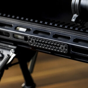 black, short rail cover on side of AR with stand and scope