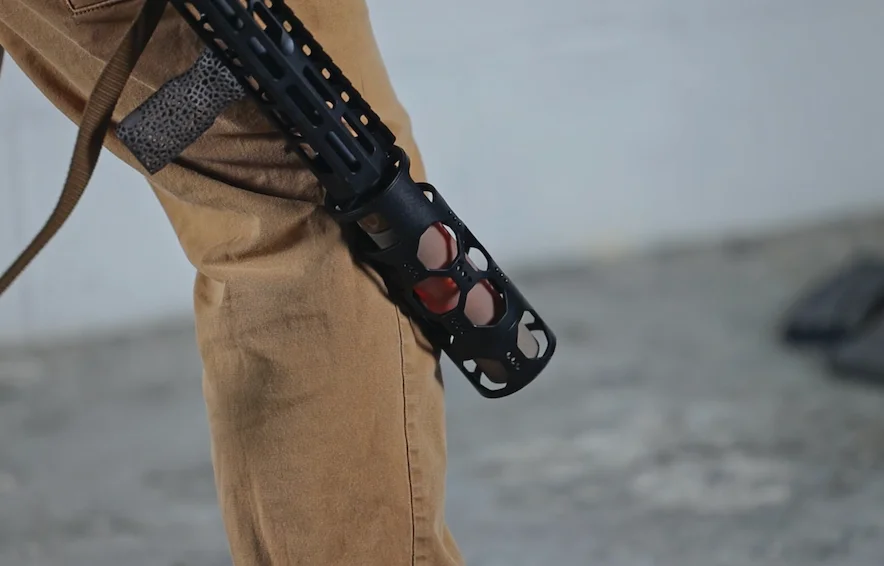 A man slinging a rifle featuring a red hot rifle barrel