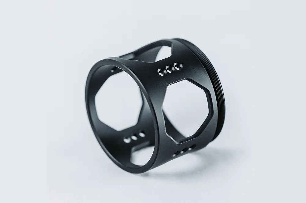 A black ring featuring multiple holes along its side, showcasing a unique and modern design.