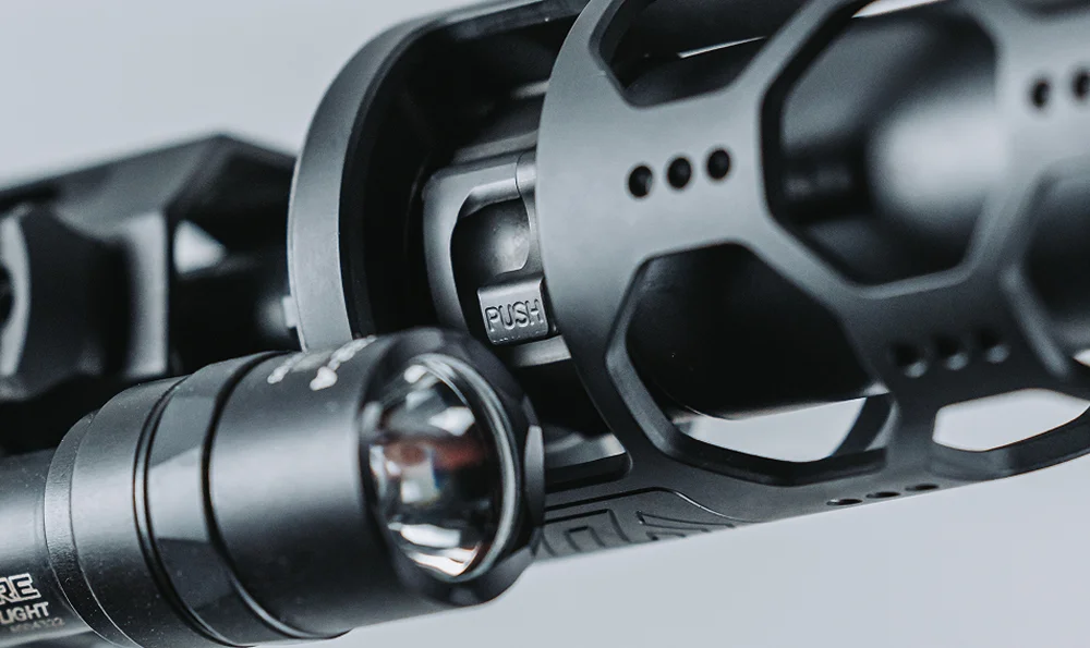 Close-up of a rifle featuring a mounted flashlight, highlighting its tactical design and functionality.