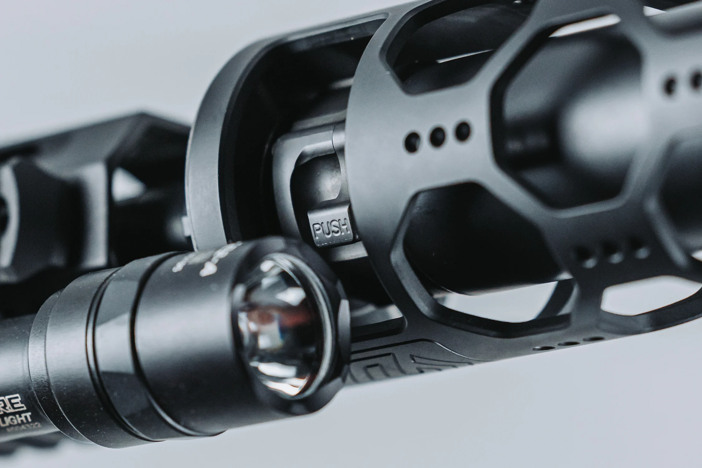 Close-up of a rifle featuring a mounted flashlight, highlighting its tactical design and functionality.